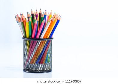 Sharp pencils arranged in a black metal holder against white background