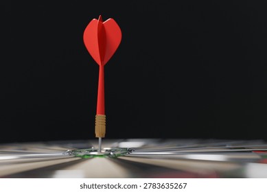 sharp red dart hitting the absolute center of a dartboard, representing success, goal achievement, perfect accuracy, and business targeting. Close-up shot with a dark, blurred background