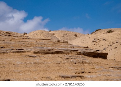 Sharp Rock Ridge and Sandy Dune Slope - Desert Terrain Contrast
​A dynamic shot showing the transition between a rocky, stratified ridge and a soft sandy slope. This image illustrates the different types of desert erosion—wind and water. Ideal for adventure travel brochures and geological research on desertification