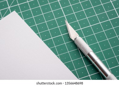 Sharp Scalpel Near Cut Paper On Cutting Mat