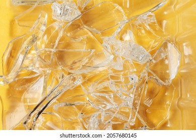 Sharp Shards Of A Broken Glass Beaker On The Yellow Floor