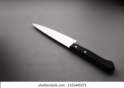 Sharp single kitchen knife in black and white with a wooden handle and a chrome silver untarnished blade