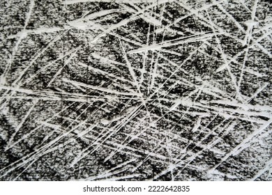 Sharp slashing white lines scratched or etched or scribbled 
				on a black crayon paper background. Dramatic dynamic abstract texture and pattern.