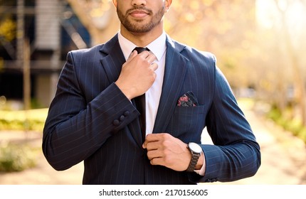 A sharp suit makes a good impression. Shot of a businessman adjusting his tie.