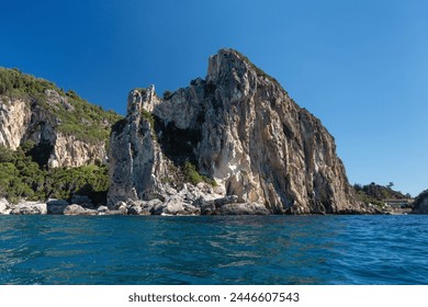 Sharp tall rocky cliffs visible above water - typical seascape near Paleokastritsa, Corfu Greece, view from a boat - Powered by Shutterstock