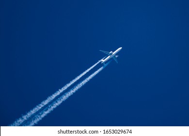 Sharp, telephoto close-up image of jet plane, aircraft with contrails cruising at 35,000 feet Tokyo to NY ground speed 480 knots
