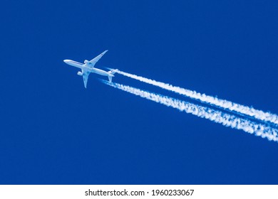 Sharp telephoto close-up of jet plane aircraft with contrails cruising from Tokyo to Chicago, altitude AGL 35,000 feet, ground speed 472 knots.