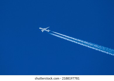 Sharp telephoto close-up of jet plane aircraft with contrails cruising from Tokyo to Chicago, altitude AGL 39,000 feet, ground speed 556 knots.