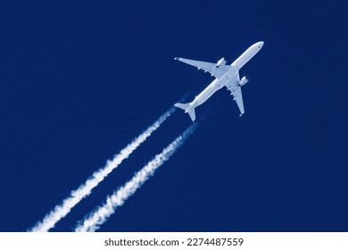 Sharp telephoto close-up of jet plane aircraft with contrails cruising from Hong Kong to New York, altitude AGL 37,000 feet, ground speed 554 knots