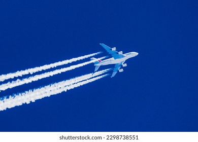 Sharp telephoto close-up of jet plane aircraft with contrails cruising from Dubai to San Francisco, altitude AGL 39,000 feet, ground speed 510 knots.
