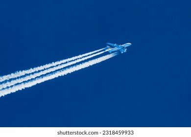 Sharp telephoto close-up of jet plane aircraft with contrails cruising from Dubai to Los Angeles, altitude AGL 39,000 feet, ground speed 551 knots.