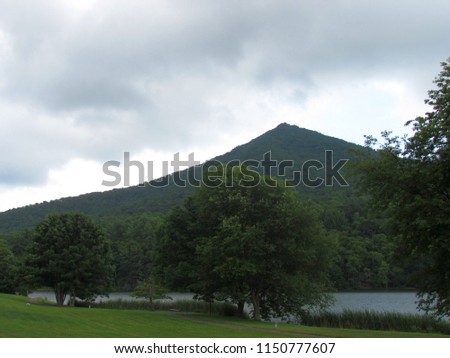 sharp top mountain peak as storm clouds move in above Abbott Lake; Bedford. VA. USA