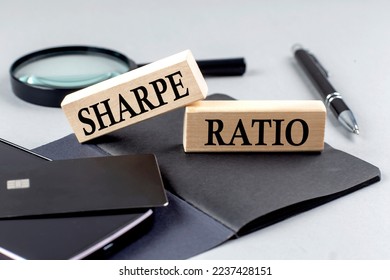 SHARPE RATIO text on a wooden block on black notebook , business concept