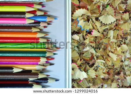 Sharpened color pencil and pencil shavings in a pencilbox