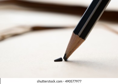 sharpened pencil tip over a blank old sheet of paper with a broken tip. - Shutterstock ID 490577977
