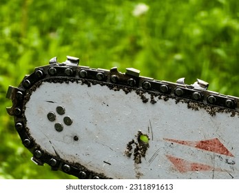 Sharpened sharp teeth of an electric saw chain on a blurred green background. - Powered by Shutterstock