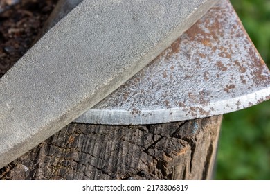 A Sharpening Stone And An Ax Blade. Blade Sharpening Tool.