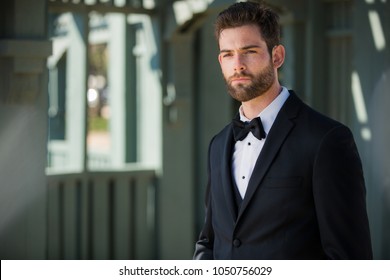 Sharply dressed groom in black tuxedo looking polished, chic, dapper, and dignified