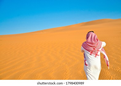 Sharurah, Saudi Arabia ,Feb 20, 2018 On 3:55 PM A Man In An Arab Costume Stands In The Middle Of The Desert, Looking At The Horizon Wearing Sunglasses Carrying A Rosary In His Hand