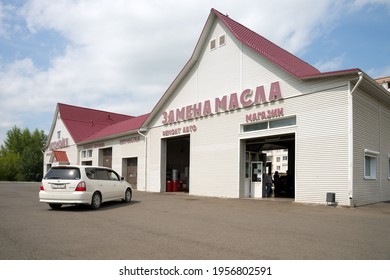 Sharypovo, Krasnoyarsk Territory, RF - July 21, 2018: The Car Stands In Front Of The Building Of A Tire Workshop And A Car Wash With An Inscription In Russian - Oil Change, On A Summer Day.