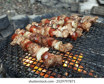 Šašlik (Shashlik) contain Marinated Meats, Sausage and Onion is being grilled on skewers over coals at Summer Outdoor Party. Leisure, Food, and Holiday Concept. - Powered by Shutterstock