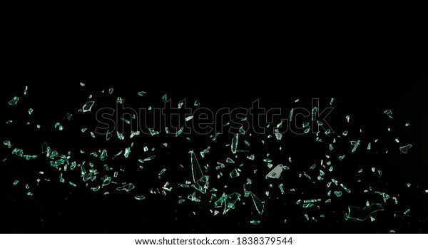 Shattered and broken glass
shards flying through the air after crush broken window on a black
background