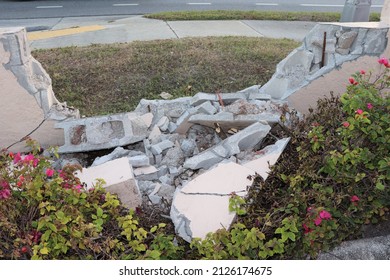 Shattered Concrete Block Wall Near Colorful Flowers