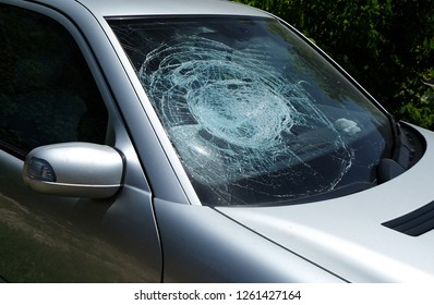 Shattered cracked broken damaged crashed car windshield at the right passenger side after a car accident. Dangerous, careless, unsafe, drunk, impaired  driving, DUI, car crash injury fatality concept.