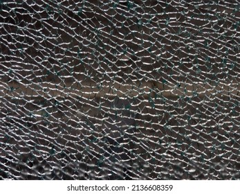 Shattered glass in a broken window
                    