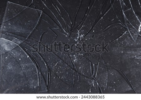 Shattered glass fragments scatter upon shadowed ground, an intricate texture overlaying the dark canvas of reality.
