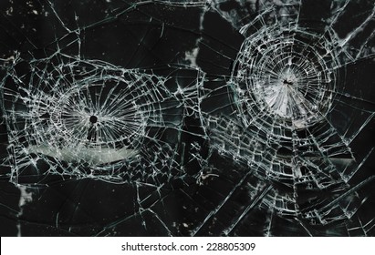 Shattered glass window with two holes                               