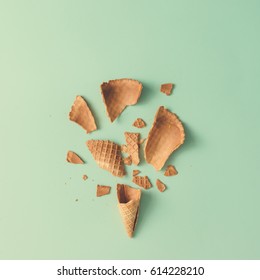 Shattered Ice Cream Cone On Pastel Blue Background. Minimal Food Concept. Flat Lay.