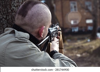 Shaved Skinhead Is Aiming At The Window