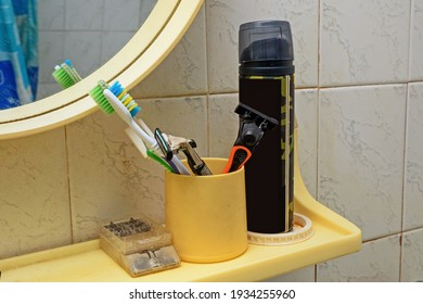 Shaving And Dental Care Supplies On The Bathroom Shelf Close-up