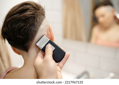 Shaving Head Hair With An Electric Razor. A Man's Hand Makes A Short Haircut To His Wife In The Bathroom.