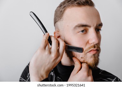 Shaving with straight razor. Brutal hairstylist in barbershop. Bearded elegant mature man works at barbershop. Stainless Steel Straight Edge Razor. Classic shave. Bearded man hold vintage razor