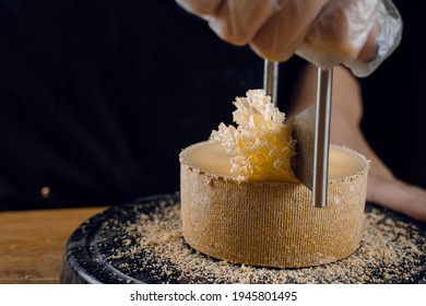 Shaving tete de moine cheese using girolle knife. Variety of Swiss semi-hard cheese made from unpasteurized cows milk, the name Monks head