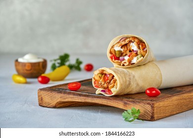  Shawarma with chicken  and garlic sauce on wooden board. Closeup                             