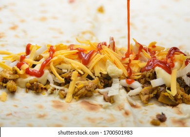 Shawarma cooking, fried meat, grated cheese, mayonnaise, salad and ketchup in pita bread - Shutterstock ID 1700501983