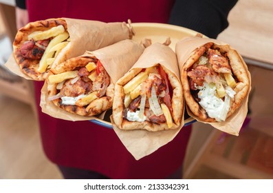 Shawarma, Gyro Pita.  Greek Food, Sliced Meat, Potato, Tomato And Tzatziki, Paper Wrap Served In A Plate, Close Up View. 
