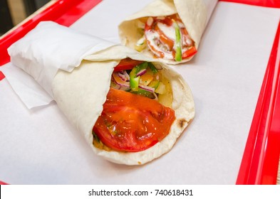 Shawarma meat chicken roll in a pita with fresh vegetables. Junk food