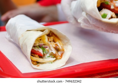 Shawarma meat chicken roll in a pita with fresh vegetables. 