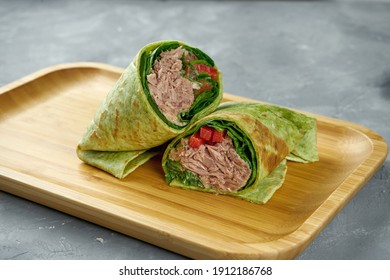 Shawarma Roll With Tuna, Bell Pepper, Carrots And Salad Leaves In Green Pita Bread On A Wooden Board On A Gray Background. Close Up, Selective Focus