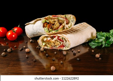 Shawarma sandwich gyro fresh roll of lavash (pita bread) chicken beef shawarma falafel RecipeTin Eatsfilled with grilled meat, mushrooms, cheese. Traditional Middle Eastern snack. On wooden background