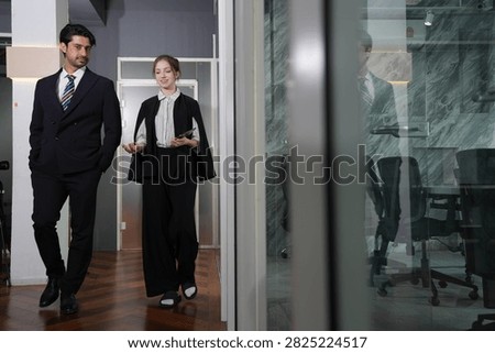 She angles her face toward him making her point on the move, his head inclined to catch her words in the quiet evening office in a bright modern coworking office.