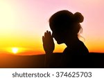 she folded her hands in prayer. beautiful sunset.