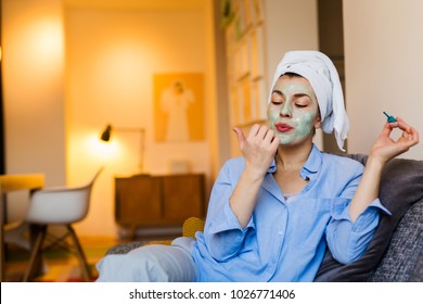 She Is Going Out Tonight. Woman With Face Mask Polishing Nails At Her Home