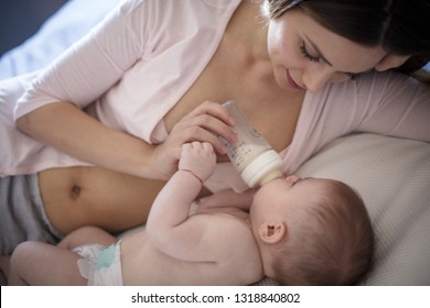 She Has That Mother's Instinct. Mother Feeding Baby With Milk. Close Up.