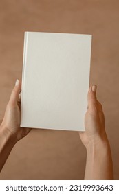 She is holding an empty notebook or book. Mockup book. Blank notebook, blank book