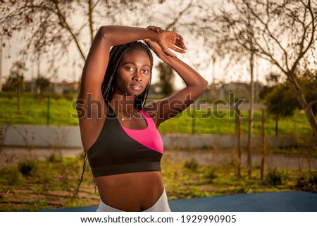 she is looking at the camera and has her arms above her head and a realxing expression.